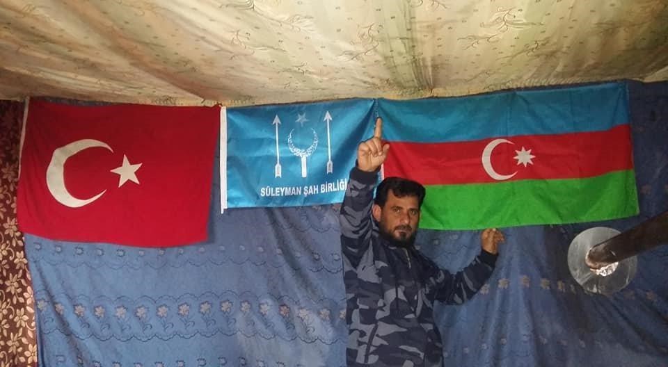 Halil Abu Nejim with an Azerbaijani, Turkish, and SSU flags making the Islamic sign of “shahada” (martyrdom), July 2, 2019, (Photo used with permission, courtesy of Bellingcat)