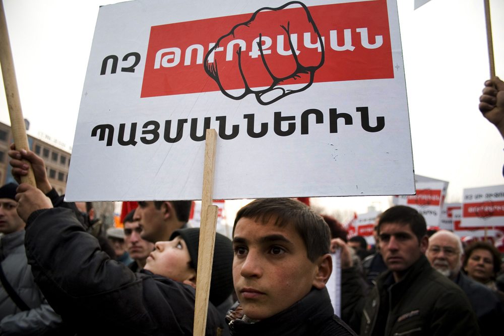 A young protester holds a sign that reads, ‘No to the Turkish preconditions,’ during a demonstration held in Yerevan in 2009 (Photo: Inna Mekhitarian/Hairenik/Armenian Weekly)